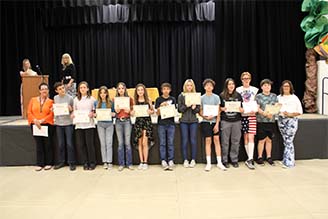 Students posing for photo with awards