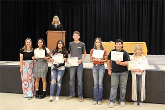 seven students holding awards